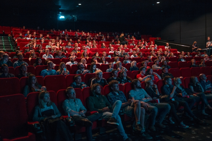 People sitting in cinema screen watching a film