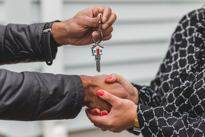 Couple shaking hands and exchanging house keys