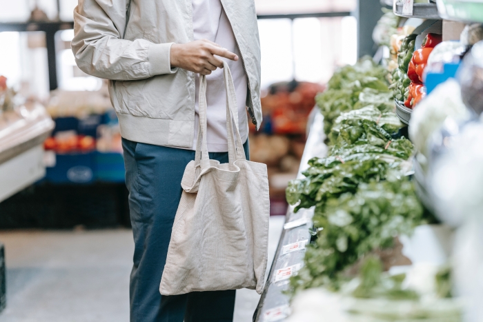 Are supermarket loyalty cards worth it? Person holding tote bag in supermarket