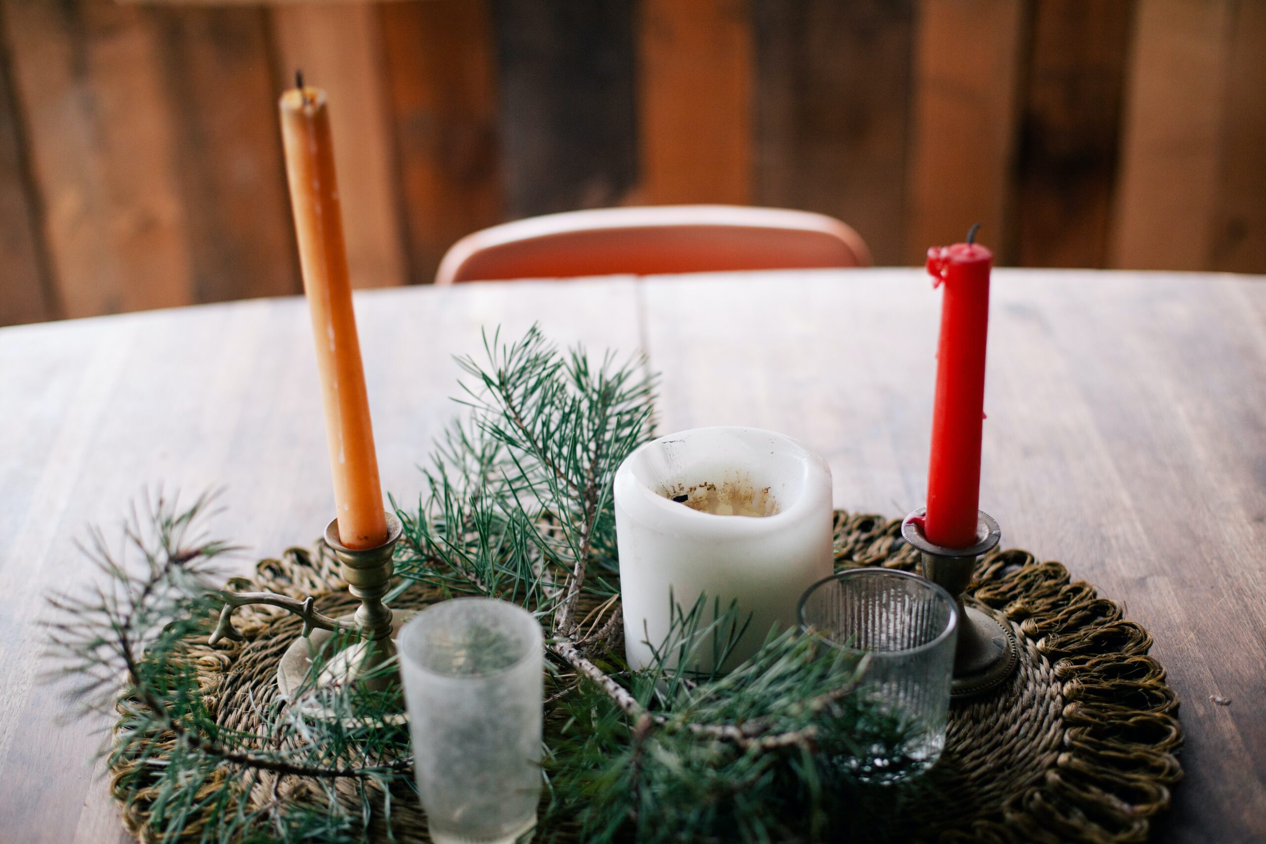 A sustainable Christmas table setting with budget-friendly candles and pine branches.