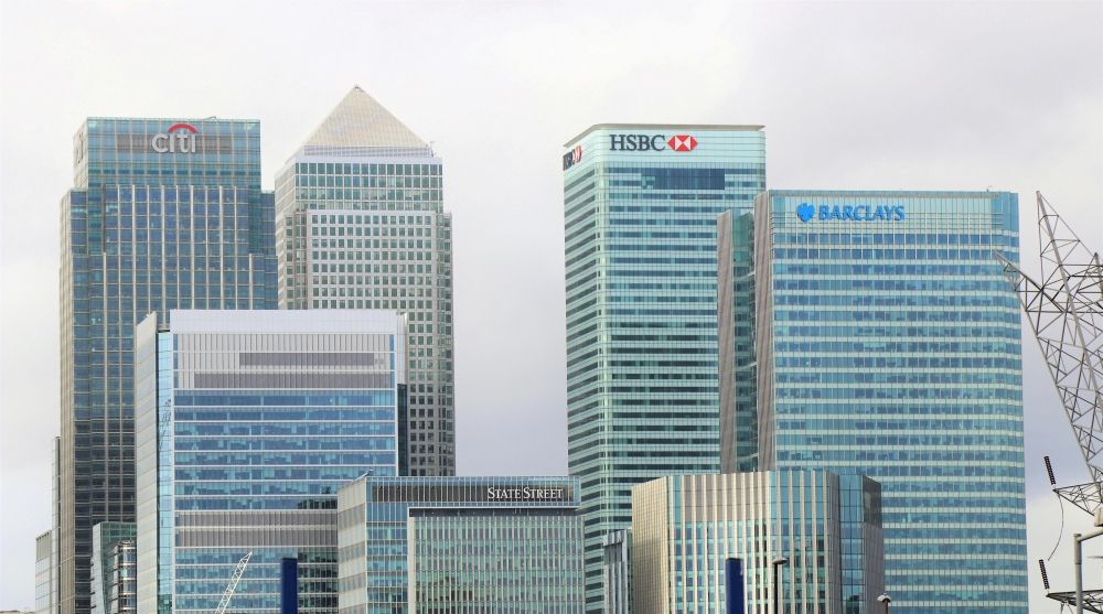 Skyline view of modern high-rise buildings with prominent logos of major banks including Citi, HSBC, Barclays, and State Street.