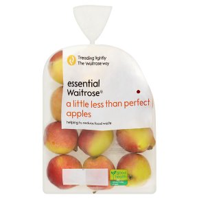 A plastic bag containing several apples labeled "essential Waitrose a little less than perfect apples, helping to reduce food waste." The bag is partially transparent, showing the apples inside.