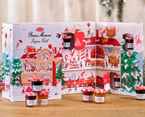 An advent calendar labeled "Bonne Maman Joyeux Noël," with compartments containing small jars of preserves. Additional jars are placed in front of the calendar.