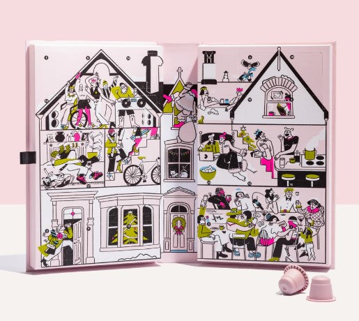 Illustration of a dollhouse-like book showcasing various domestic and whimsical scenes. Two pink coffee pods lie in the foreground.