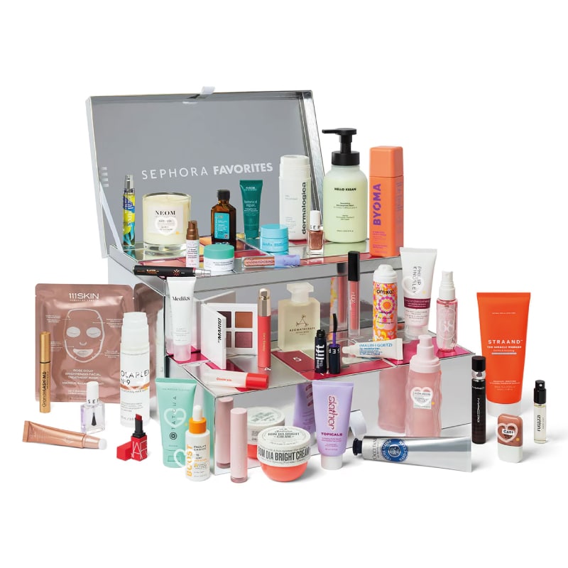 An assortment of skincare and beauty products is displayed, including creams, serums, masks, and cosmetic items, organized in a multi-tiered clear acrylic stand labeled "Sephora Favorites.