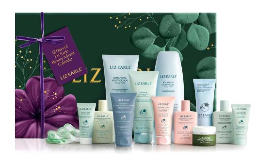 A collection of Liz Earle skincare products, including creams, cleansers, and serums, displayed in front of a green and purple gift box.