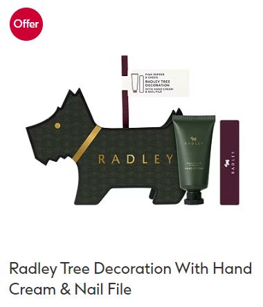 Dog-shaped Radley tree decoration with a hand cream tube and a nail file, displayed against a white background. An "Offer" label is shown in the upper left corner.