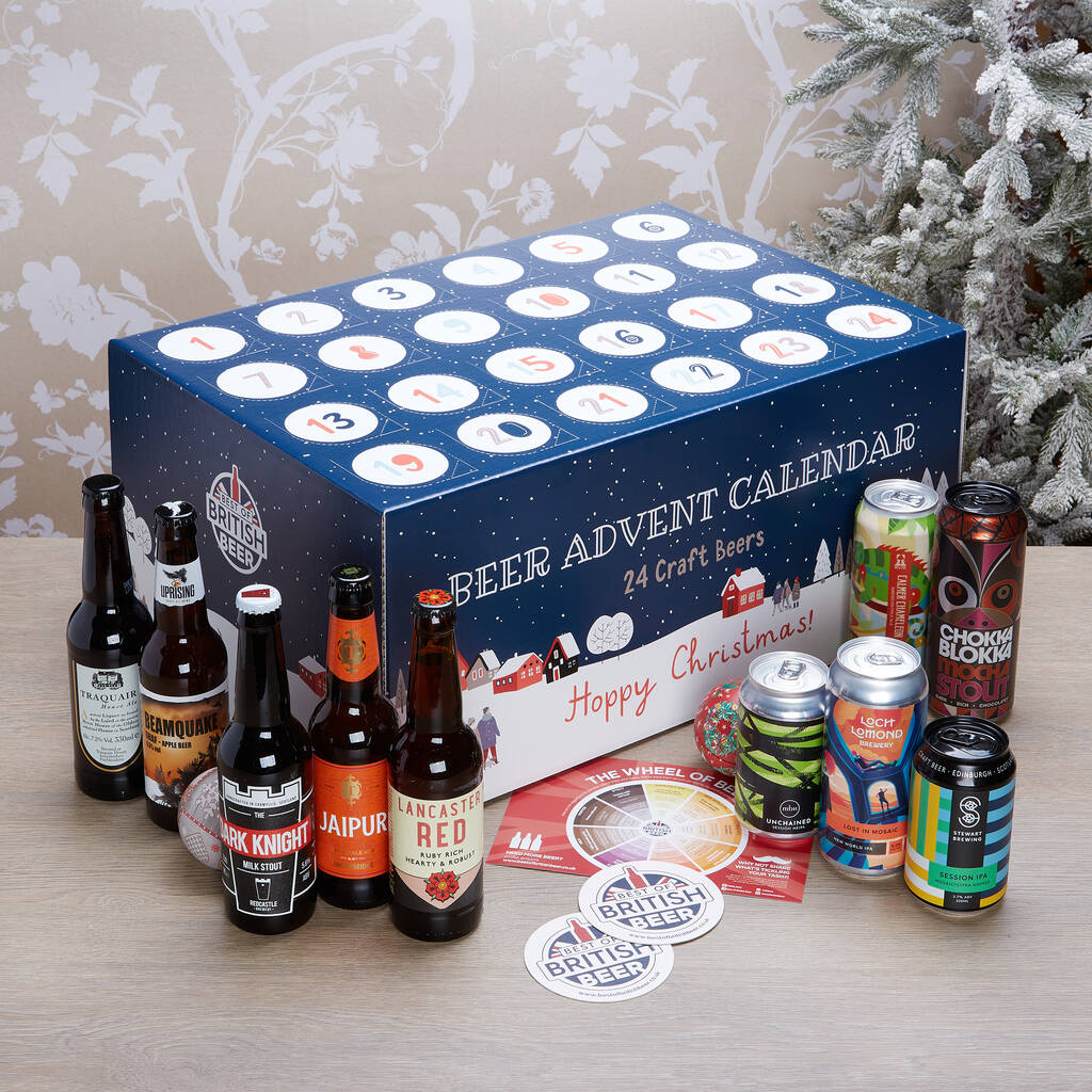 A beer advent calendar with 24 slots, surrounded by various craft beer bottles and cans, and coasters on a table.