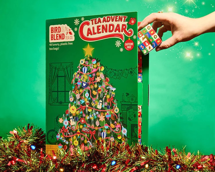 A human hand opening the green Bird Blend tea advent calendar