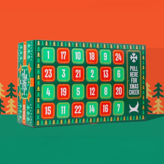 Colorful advent calendar box with numbered compartments and the text "Pull here for Xmas cheer." Background features stylized trees on an orange and green backdrop.