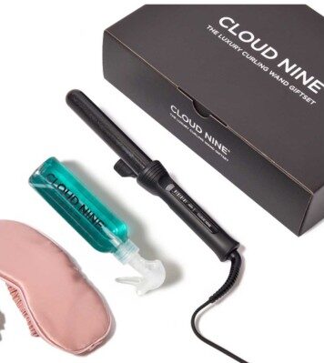 Cloud Nine curling wand set with a black curling wand, teal styling spray, a pink silk sleep mask, and a black box.