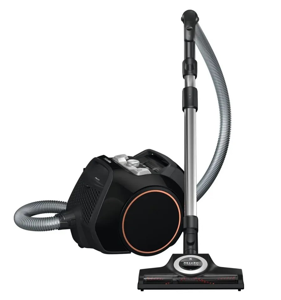 A black canister vacuum cleaner with a flexible hose and a wheeled base. Attached to the hose is a long metal tube and a rectangular floor nozzle.