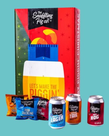 Gift box with assorted snacks and drinks. Includes packets labeled "Pork Crackling" and cans labeled "Lager" and "Tail." Box reads "Let's Make the Piggin' Happen.