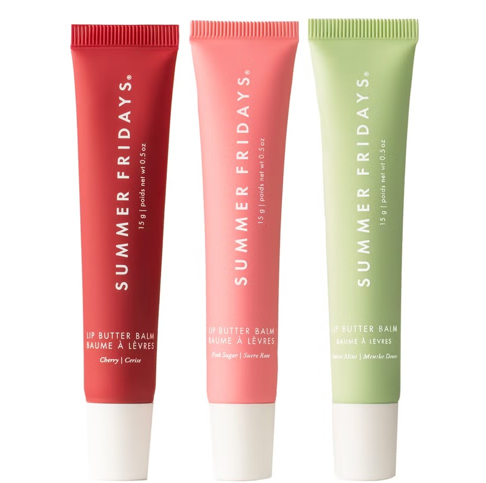 Three tubes of Summer Fridays lip butter balm are displayed in red, pink, and green packaging, labeled with flavors: Cherry, Pink Sugar, and Vanilla Mint.