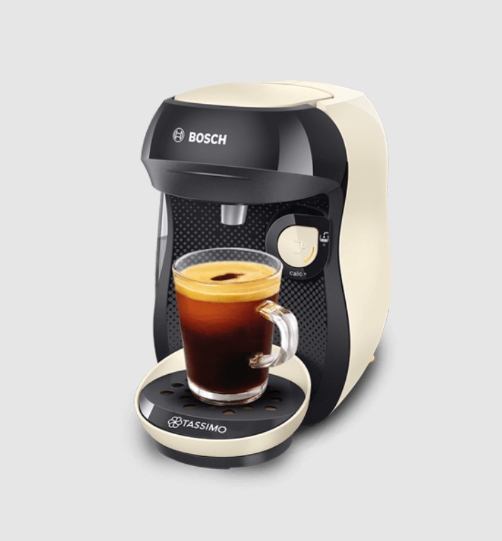 A Bosch Tassimo coffee machine with a single cup of coffee in the tray, against a plain backdrop.