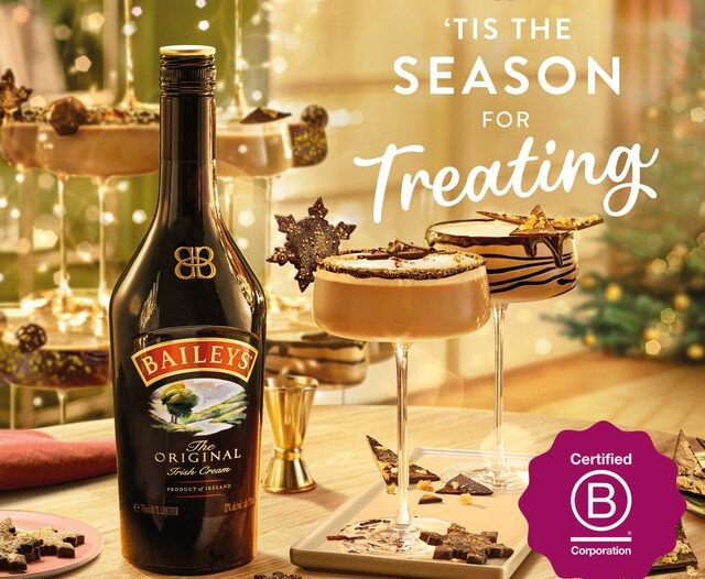 Baileys bottle and glasses with festive treats on a table, surrounded by holiday decorations. Text: "'Tis the Season for Treating. Discover the best Baileys offers and make your celebrations even sweeter.