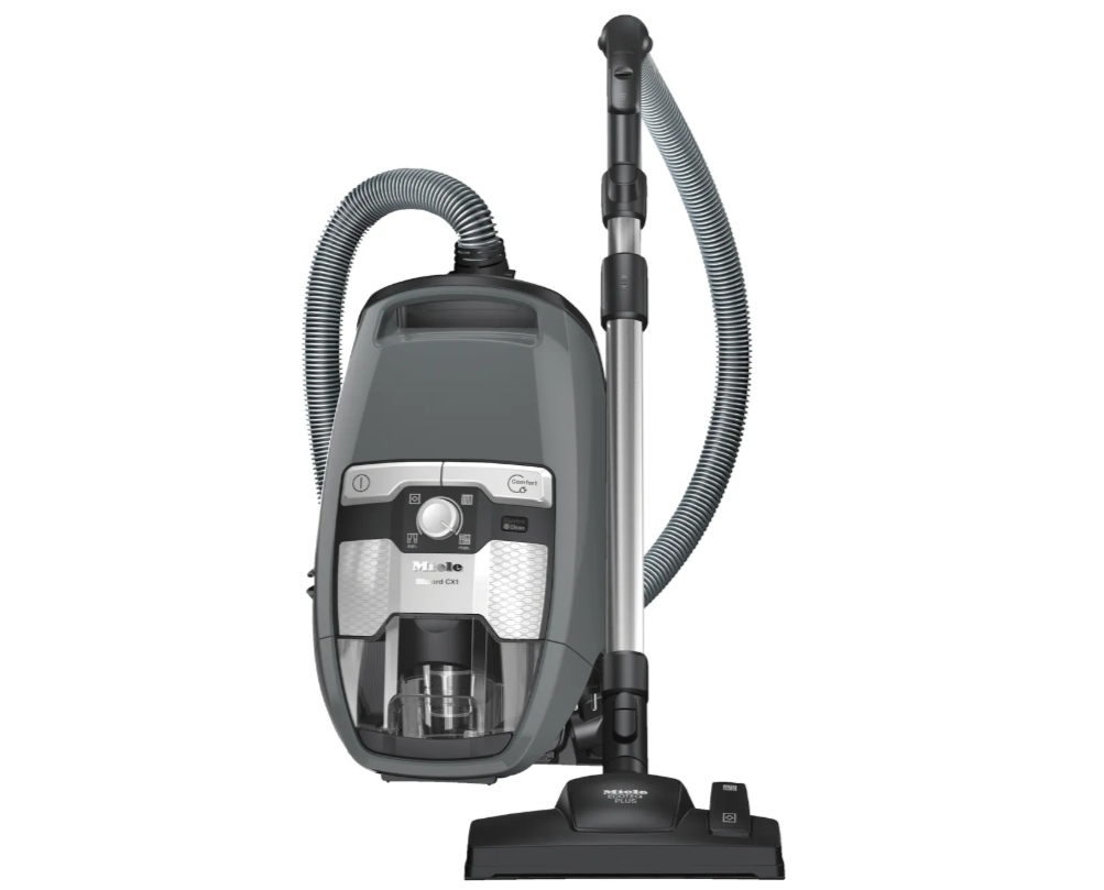 A gray and black canister vacuum cleaner with a detachable hose and floor attachment.