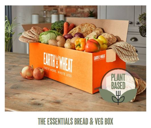 Open box of assorted breads and vegetables from Earth & Wheat, labeled "Plant Based," with onions on the side.