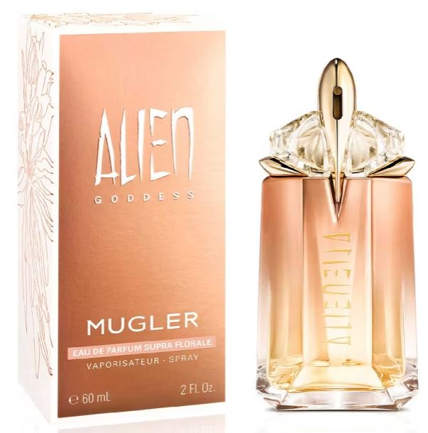 A bottle of Mugler's "Alien Goddess" perfume next to its packaging. The bottle is gold-toned with a crystal-like cap.