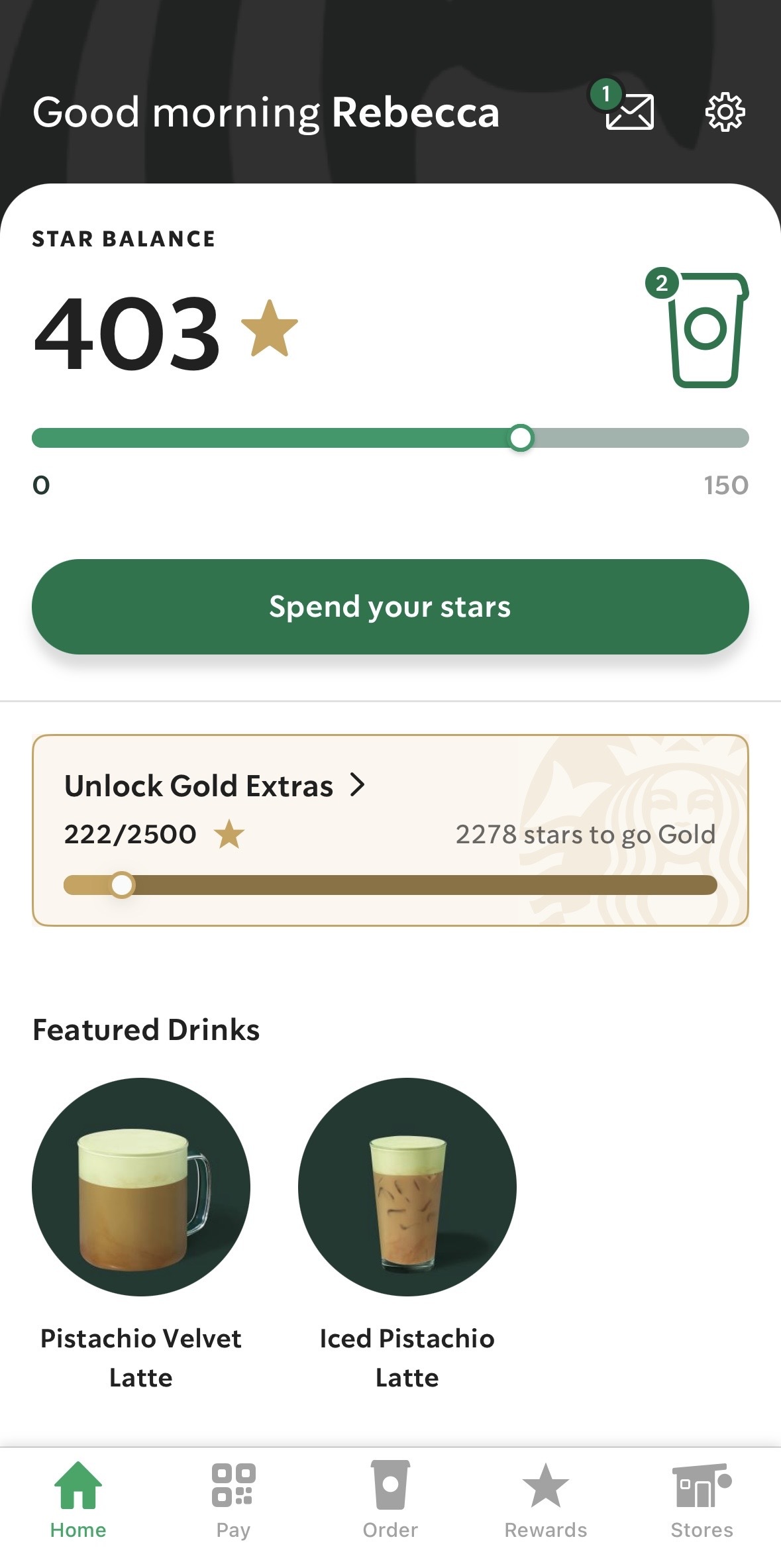 App interface showing user's star balance of 403, with options to spend stars or unlock gold extras. Featured drinks include Pistachio Velvet Latte and Iced Pistachio Latte.