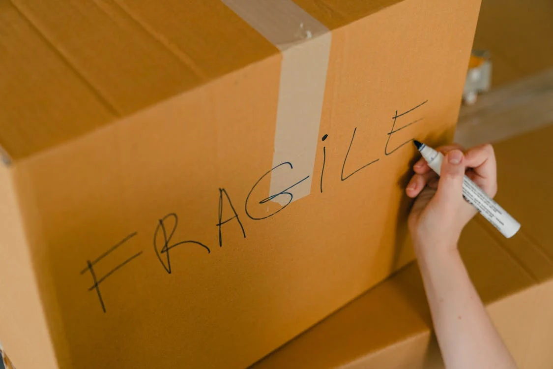 Someone packing fragile deliveries from an Amazon return pallet