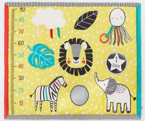 Brightly colored baby activity mat with animals, a growth chart, and a "1 Day" badge, featuring a lion, zebra, elephant, octopus, and leaves on a yellow background with polka dots.